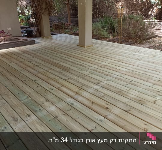 דק עץ חדש בגינה עם עמודים ותאורה